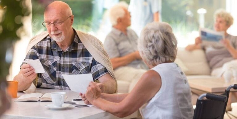 Elderly Couple Relaxing and Talking in Bright Memory Care Facility