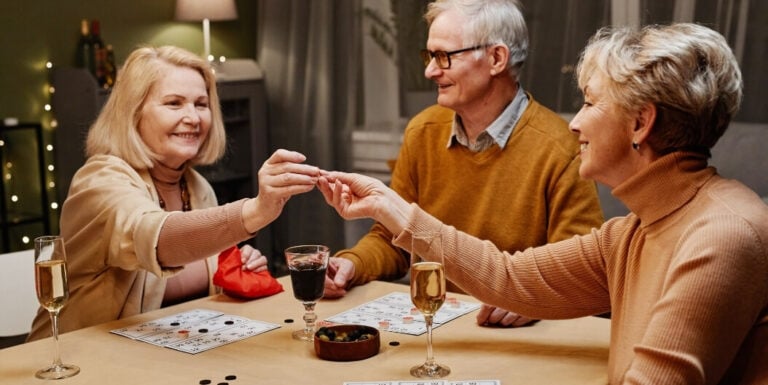 Elderly Friends Playing Cards over Wine at Assisted Living Facility